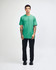 A model wearing a turquoise unisex fine jersey short sleeve t-shirt paired with khaki pants. The shirt has a logo.