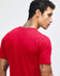 A unisex fine jersey short sleeve t-shirt in red, paired with black pants, with a logo present.