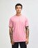 A unisex short sleeve T-shirt in pink, featuring a crew neck and a plain design, with a logo present.