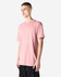 A unisex short sleeve T-shirt in soft pink, featuring a relaxed fit and a logo on the brand label.