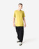 A unisex short sleeve t-shirt in yellow, paired with dark cargo pants and sneakers, worn by a standing model.