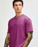 A unisex short sleeve t-shirt in a vibrant magenta colour, worn by a model with a neutral expression.
