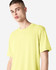 A model wearing a bright yellow unisex short sleeve t-shirt with a simple design and no visible logos.