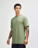 A green unisex CVC short sleeve T-shirt displayed on a model, featuring a subtle texture and relaxed fit.