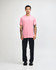 A model wearing a pink unisex CVC short sleeve t-shirt paired with dark cargo pants and trainers.