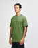 A green unisex CVC short sleeve T-shirt displayed on a model, featuring a simple design and a logo.