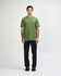 A model wearing a green unisex CVC short sleeve T-shirt paired with black cargo pants and sneakers.