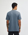 A unisex short sleeve T-shirt in a blue hue, featuring a simple design and a brand logo.
