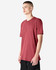 A unisex short sleeve t-shirt in a red hue, displayed on a model with a minimalistic background, featuring a logo.