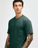 A unisex CVC short sleeve t-shirt in dark green, featuring a simple design and a branding logo.