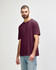 A maroon adult T-shirt displayed on a model, featuring a relaxed fit and short sleeves. Logo present.