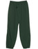 Green kids' warm-up pants featuring an elasticated waistband and a drawstring, with side pockets and fitted cuffs.