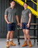 A pair of models wear unisex cotton stretch ripstop work shorts in navy, paired with grey polo shirts and work boots.
