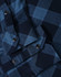 A blue and navy plaid flannel shirt with button-up detailing and a pocket. It features metal snap buttons.