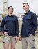 A closed front long sleeve work shirt in navy, displayed on a male and female model in a construction setting.