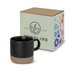 A coffee mug in black with a beige base, accompanied by a decorative box featuring a floral design and logo.