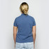 A back view of a women's polo shirt in a soft blue colour, featuring a fitted design and short sleeves.