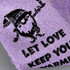 Fluffy grip socks in lavender featuring a playful design and a logo. Soft textured material for comfort.