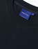 A dark navy unisex crew neck sweater with ribbed detailing and a branded label inside the collar.