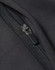 A close-up of a black softshell jacket featuring a zip with a branded pull tab.