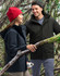A unisex quilted waterproof jacket in navy and black, displayed by a man and woman in a forest setting.