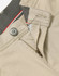 Men's flexi chino pants in beige, featuring a zip fly and button closure, with a logo on the waistband.