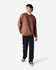 A brown Gildan Softstyle adult sweatshirt is worn by a model, paired with black pants and sneakers.