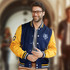 A navy and yellow custom varsity jacket with a logo and striped ribbing, worn by a smiling man.