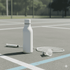 A drink bottle in white, positioned on a tennis court alongside a racquet and shuttlecock.