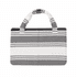 A foldable beach towel bag in grey and white stripes, featuring sturdy handles and a fabric texture.