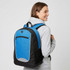 A blue and black backpack is worn by a person, featuring a front pocket and mesh side pockets.