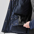 A navy puffer jacket interior featuring pockets with snap fasteners and a soft lining. It has a branded label.