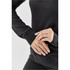 A black women's pullover hoodie featuring a textured fabric and snug cuffs, with hands positioned near the waistband.