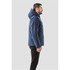 A navy blue men's jacket is displayed from the side, featuring a hood and a subtle logo.