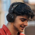 A young man wearing black Skullcandy Riff 2 wireless headphones, with a stylish design and logo visible.