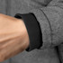 A close-up of a woman's grey puffer jacket cuff, featuring a black ribbed trim and a hand.