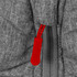 A close-up of a grey puffer jacket featuring a red zipper pull and textured fabric. The jacket has a branding logo.