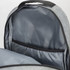 An open grey backpack reveals a spacious interior with a dark grey lining and a storage pocket.