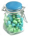 A glass clip lock jar filled with blue and green humbugs. The jar features a blue lid and a metal clasp.