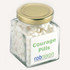 A square glass jar with a gold lid, filled with white mints. The jar features a label with a logo.