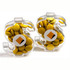 Acrylic dollar-shaped containers filled with yellow chocolate beans, featuring a logo on each.