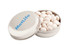 A silver tin containing white chewy mints, featuring a logo on the lid.