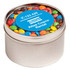 A small round tin filled with colourful M&Ms, featuring a blue label and a silver finish.