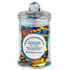A small glass apothecary jar filled with colourful chocolate beans, featuring a round lid and a logo.