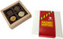 A chocolate box with a white and red exterior containing four assorted chocolates in a gold tray inside.