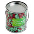 A metal bucket filled with red and green chocolate beans, featuring a festive label on the front.