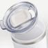 A double wall travel mug in white with a clear lid and a silver band around the top. It features a logo.