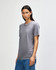 A grey American Apparel tri-blend T-shirt is displayed on a model, featuring a relaxed fit and short sleeves.