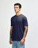 A navy American Apparel tri-blend t-shirt on a model, featuring a simple design and short sleeves.