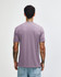 A tri-blend t-shirt in a muted purple colour, viewed from the back, worn by a person with tattoos.